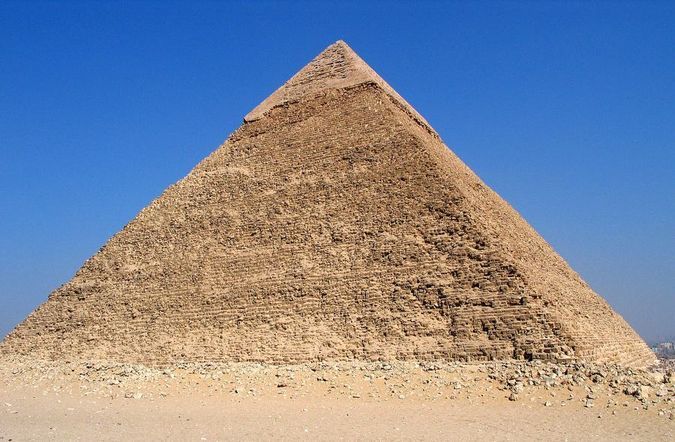 The Pyramid of Khafre at Giza rising above the desert, its smooth casing stones still visible near the summit.